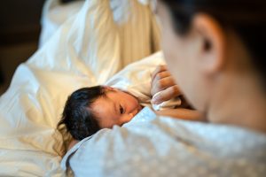 Mother breastfeeding newborn baby in a hospital
