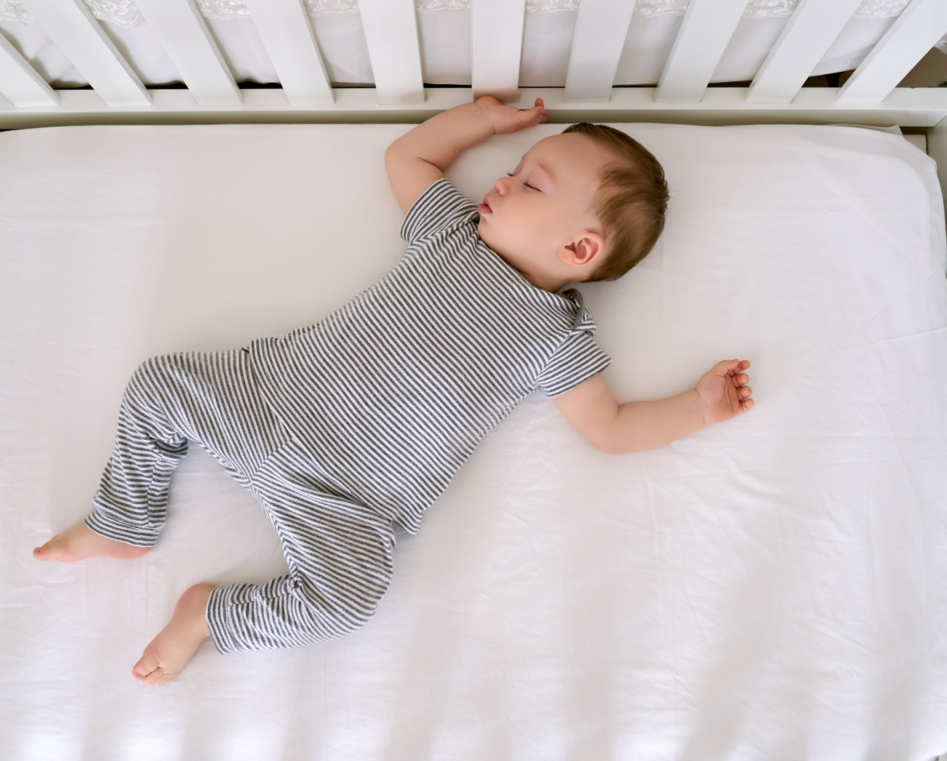 A baby sleeps in a crib