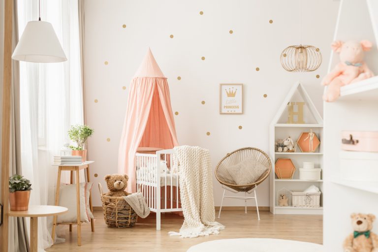 Gold and pink baby nursery with a canopied cradle