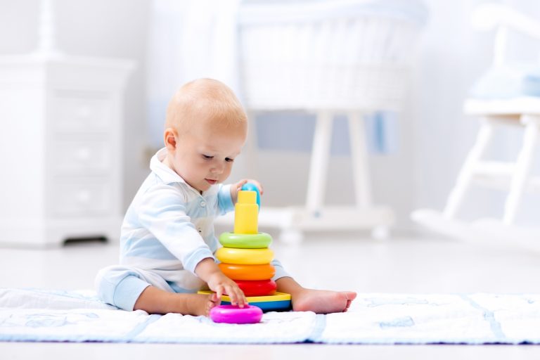 Baby playing with toy pyramid.