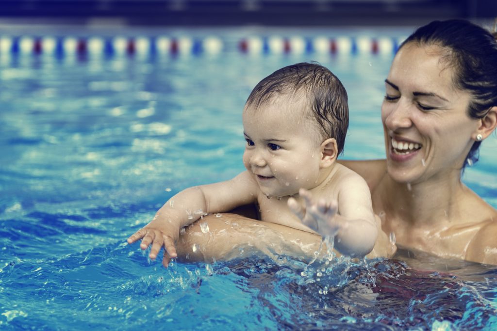A baby kin the pool with mom