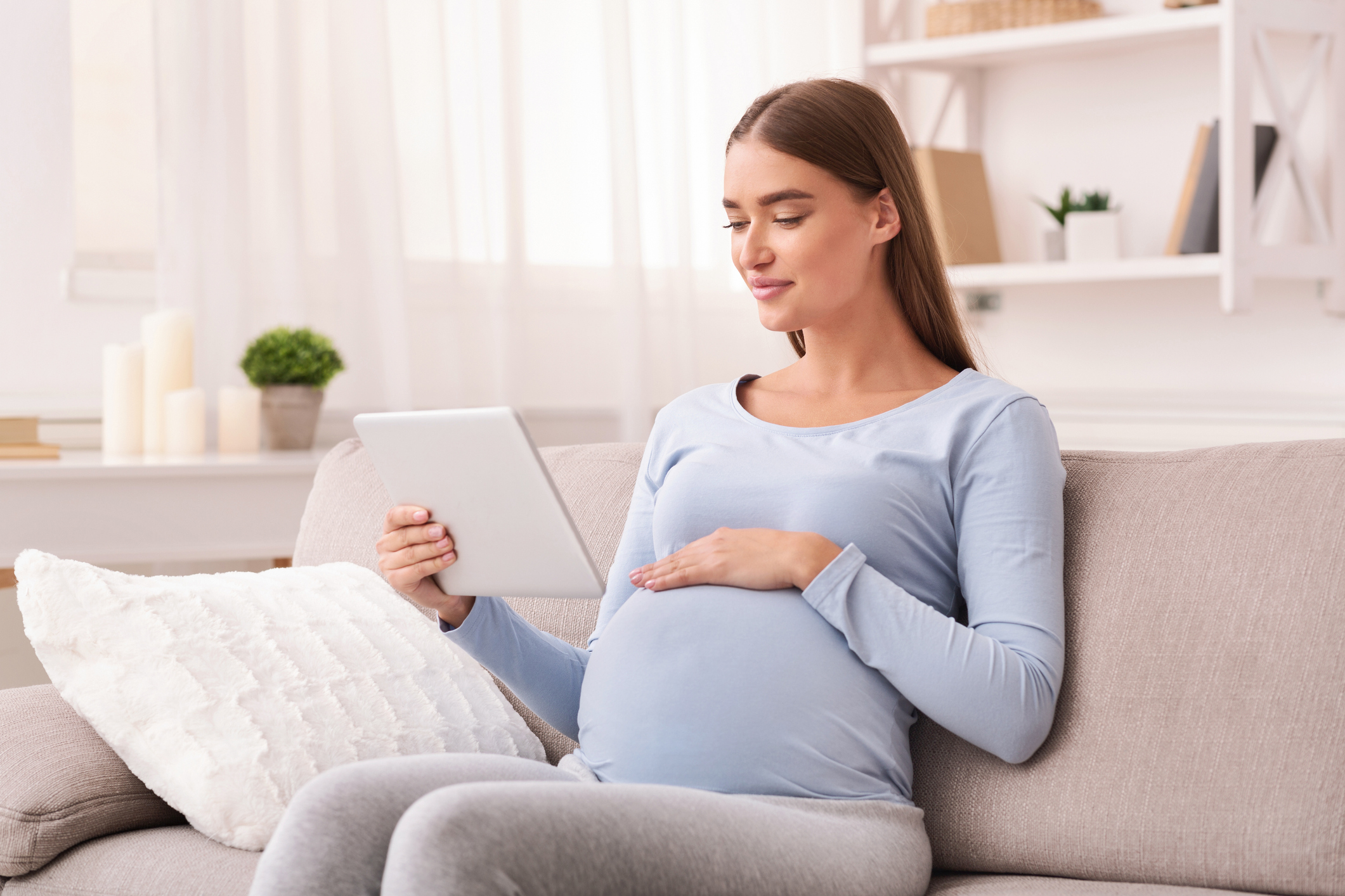 A pregnant woman uses a tablet computer