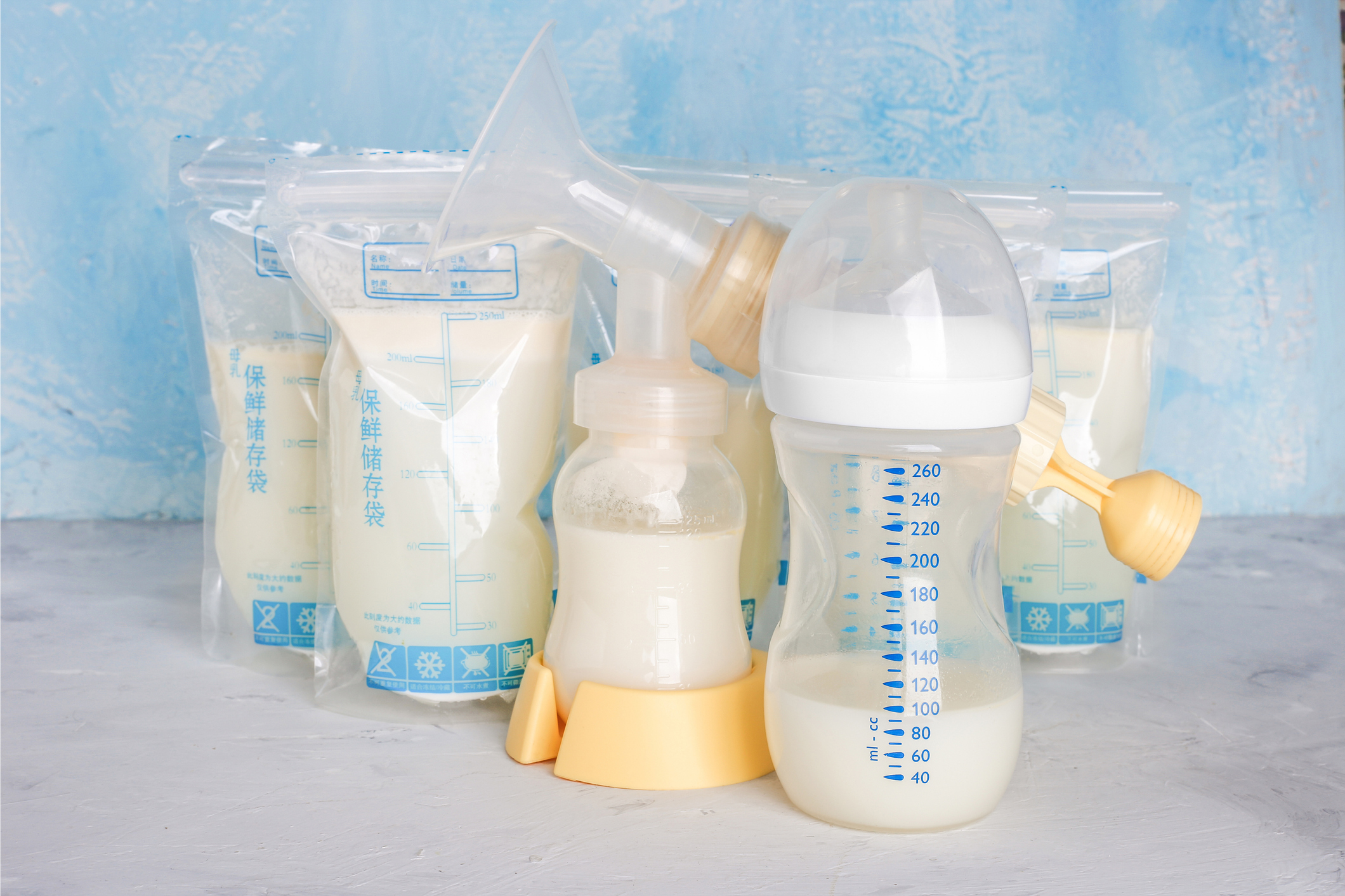 Bags of breastmilk defrosting with baby bottles