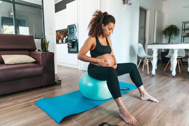 Woman exercising at home while pregnant