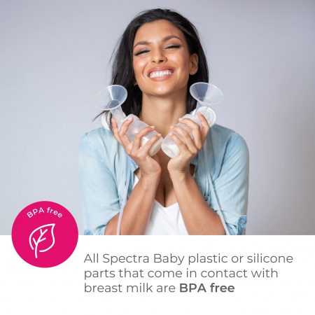 A woman holder her breast pump and smiles