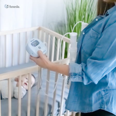 A mom pumps with the Ameda Mya breast pump in front of her baby's crib