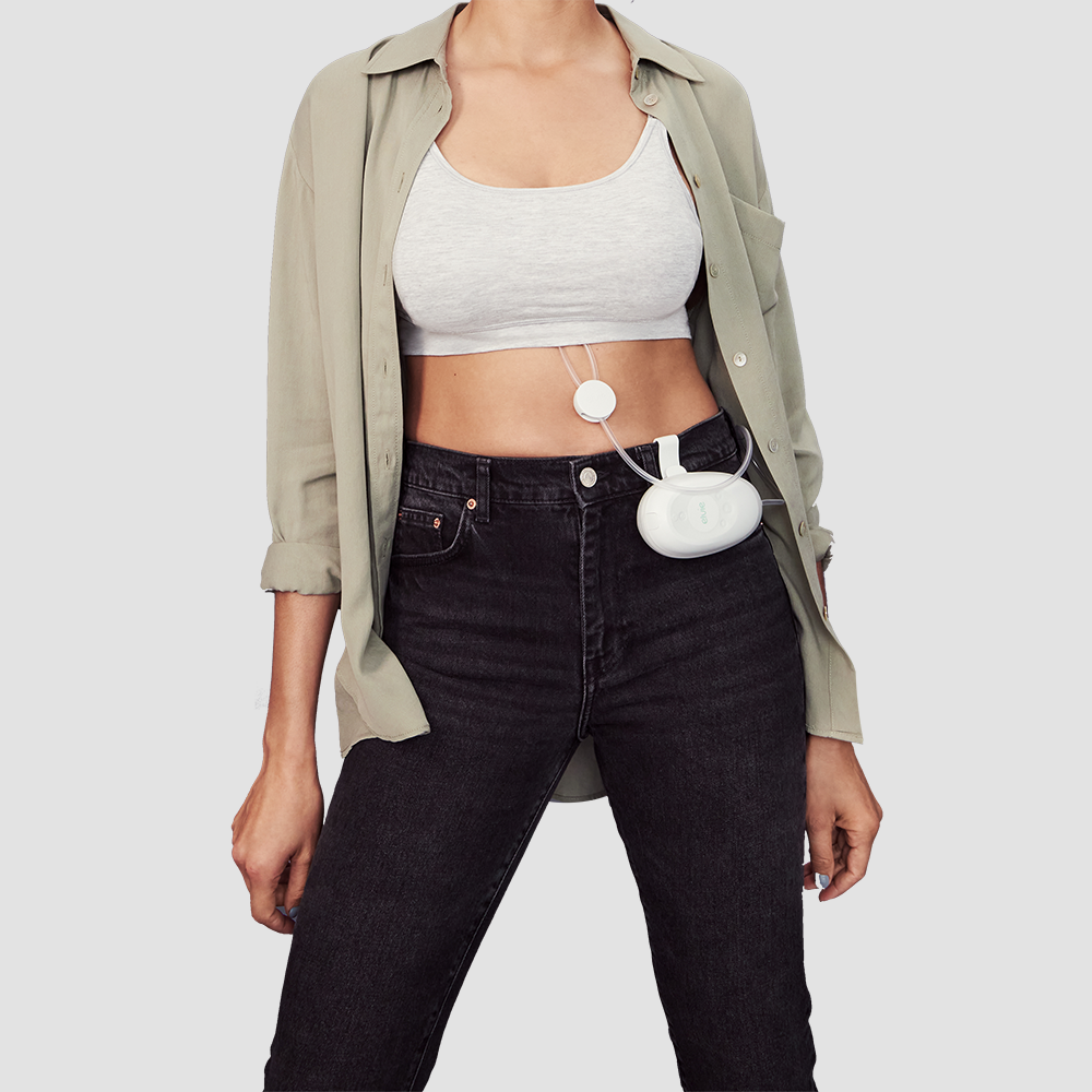 A woman uses an Elvie Stride breast pump under her clothing