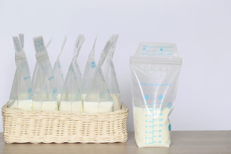 frozen breast milk storage bags for new baby on wooden table