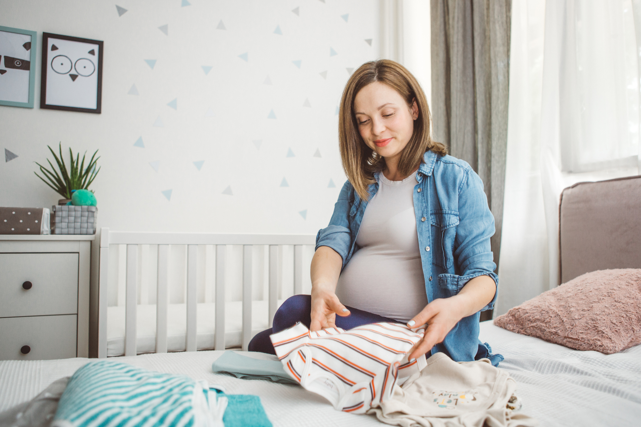 Pregnant woman arranging clothes