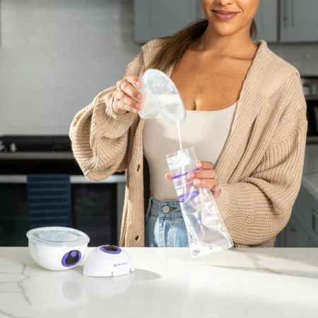 An image of a mom pouring breast milk into the Lansinoh Discreet Duo Wearable Pump milk storage bags